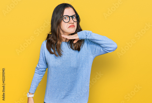 Young beautiful woman wearing casual clothes and glasses cutting throat with hand as knife, threaten aggression with furious violence photo