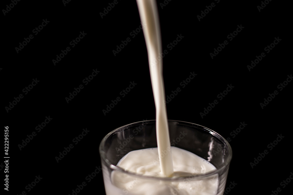 pouring milk in a glass. splash of white liquid isolated on dark background pouring milk in a glass. splash of white liquid isolated on dark background