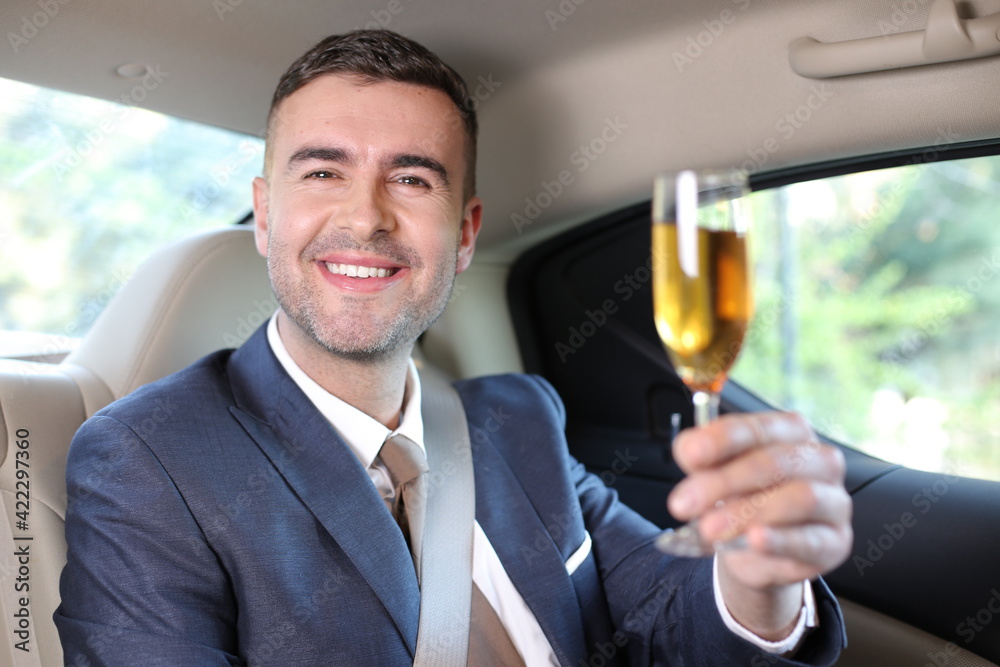 Elegant man drinking champagne in limousine  - obrazy, fototapety, plakaty 