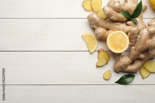 Fresh lemon and ginger on white wooden table, flat lay. Space for text