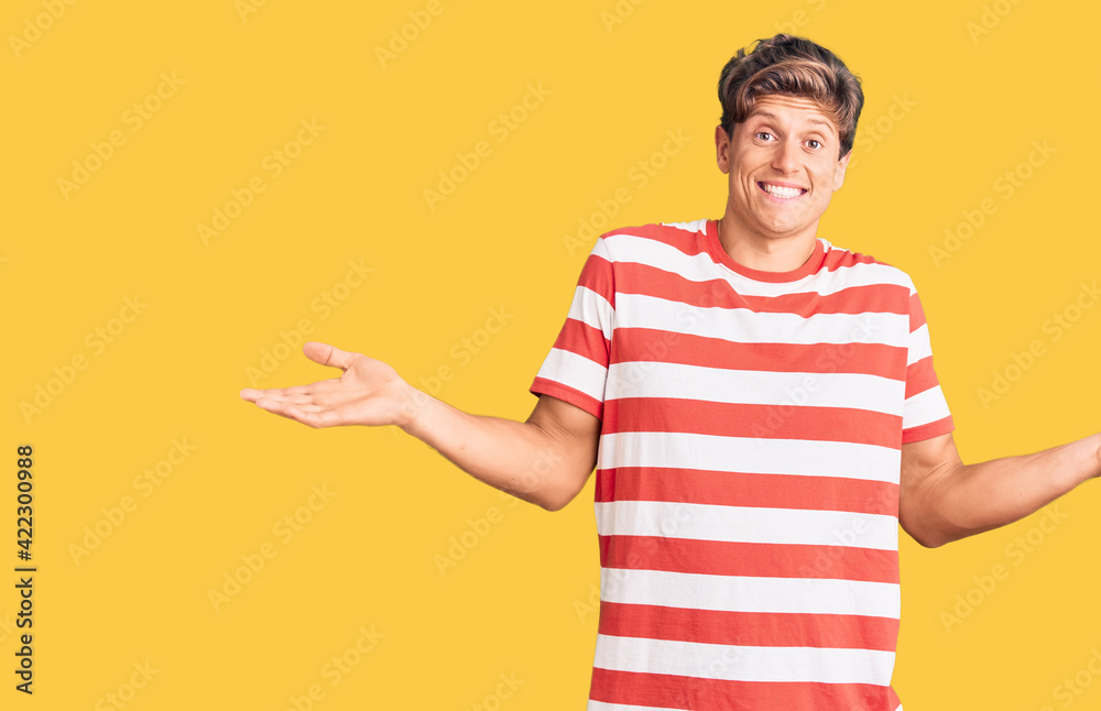 Young handsome man wearing casual clothes clueless and confused expression with arms and hands raised. doubt concept.