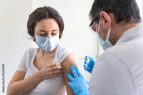 Doctor applying a vaccine on a woman's arm . photo