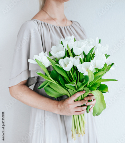 White tulips buquet woman holding, natural tones, with nordic vibes