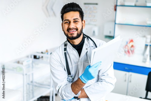 Portrait of a smiling Indian doctor at work  he looks at the camera  modern Indian medicine  health and safety