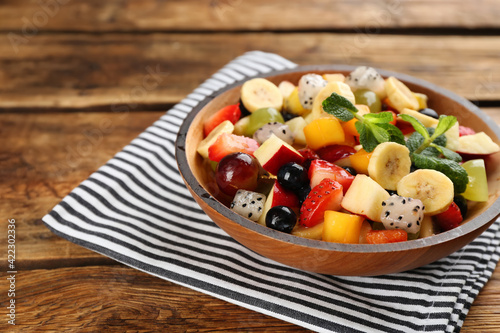 Delicious exotic fruit salad on wooden table