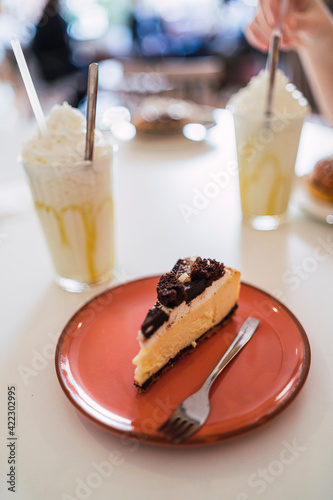Porcion de tarta y batido de helado en mesa de cafeteria