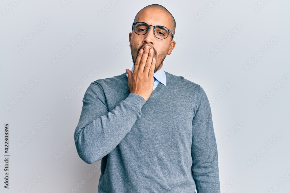 Hispanic adult man wearing glasses and business style bored yawning tired covering mouth with hand. restless and sleepiness. Hispanic adult man wearing glasses and business style bored yawning tired covering mouth with hand. restless and sleepiness.
