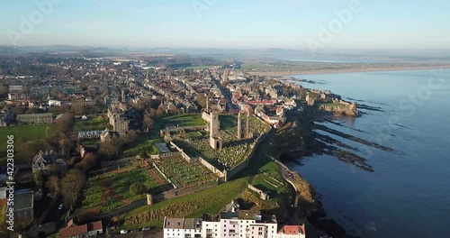 4k aerial footage of St Andrews in Fife, Scotland. High view showing beaches, cathedral, cemetery, town buildings, ruins of castle, sea, harbour, piers, university and coastline.