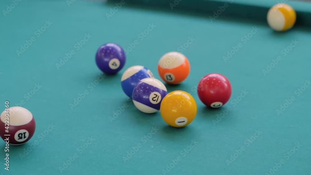 Slow motion: hitting colorful pool balls and breaking racked pool balls on teal billiards table - close up view. Sport, game, competition, hobby, leisure time concept Slow motion: hitting colorful pool balls and breaking racked pool balls on teal billiards table - close up view. Sport, game, competition, hobby, leisure time concept