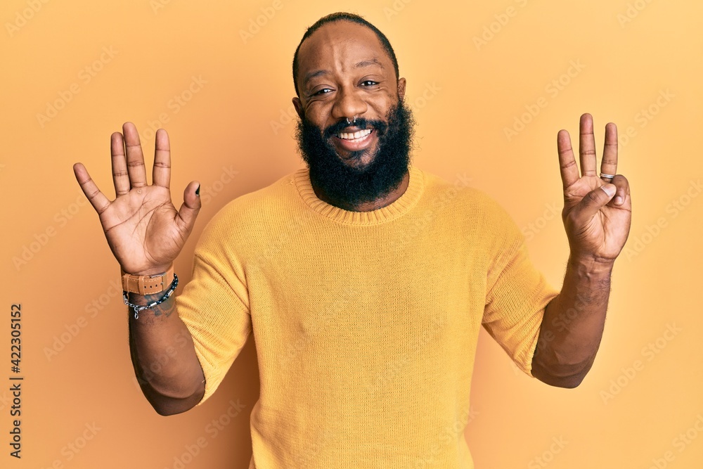 Young african american man wearing casual clothes showing and pointing up with fingers number eight while smiling confident and happy. Young african american man wearing casual clothes showing and pointing up with fingers number eight while smiling confident and happy.