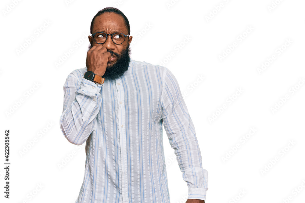 Young african american man wearing business shirt and glasses looking stressed and nervous with hands on mouth biting nails. anxiety problem. Young african american man wearing business shirt and glasses looking stressed and nervous with hands on mouth biting nails. anxiety problem.