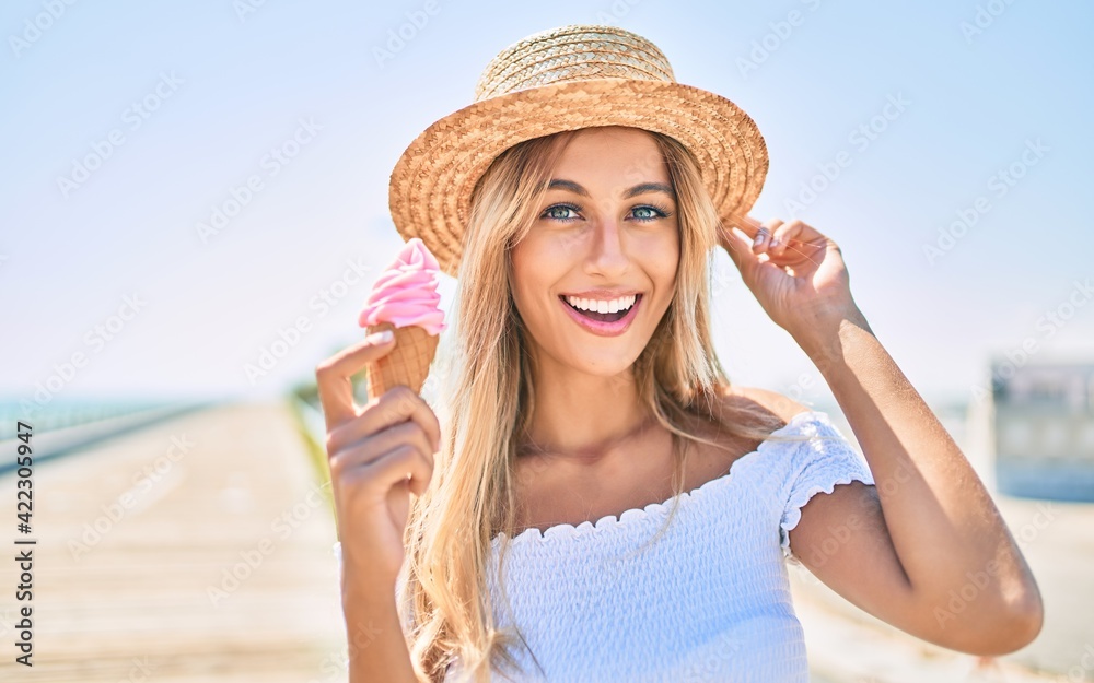 Young blonde tourist girl smiling happy eating ice cream at the promenade.
