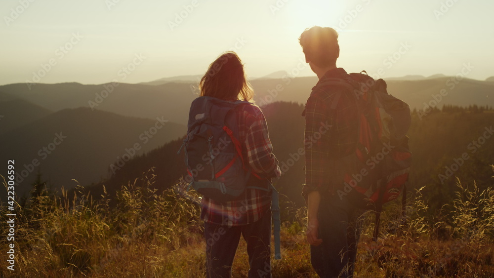 Tourists enjoying sunset in mountains. Couple spending leisure time together
