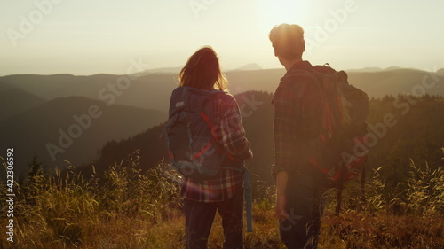 Tourists enjoying sunset in mountains. Couple spending leisure time together