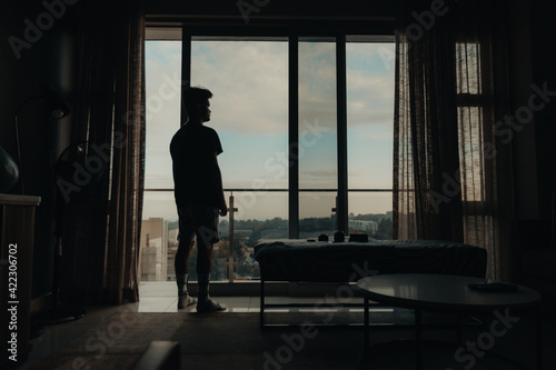 silhouette of a person standing at loft apartment window