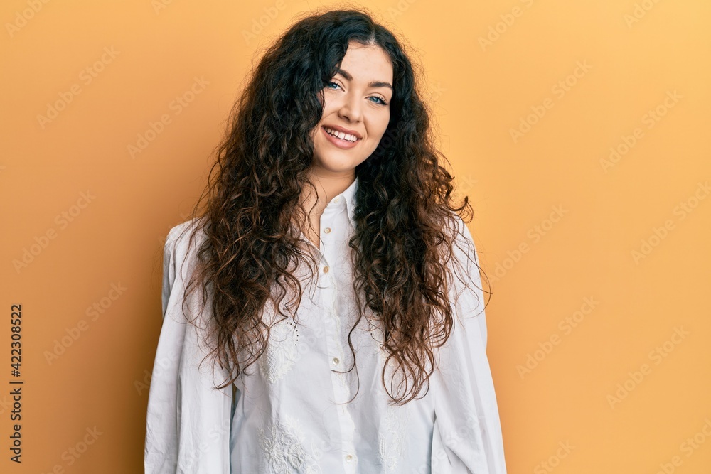 Young brunette woman with curly hair wearing casual clothes with a happy and cool smile on face. lucky person. Young brunette woman with curly hair wearing casual clothes with a happy and cool smile on face. lucky person.