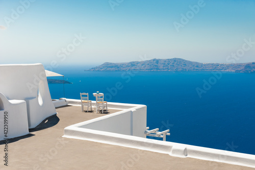 White architecture on Santorini island, Greece. Two chairs on the terrace with sea view. Famous travel destination