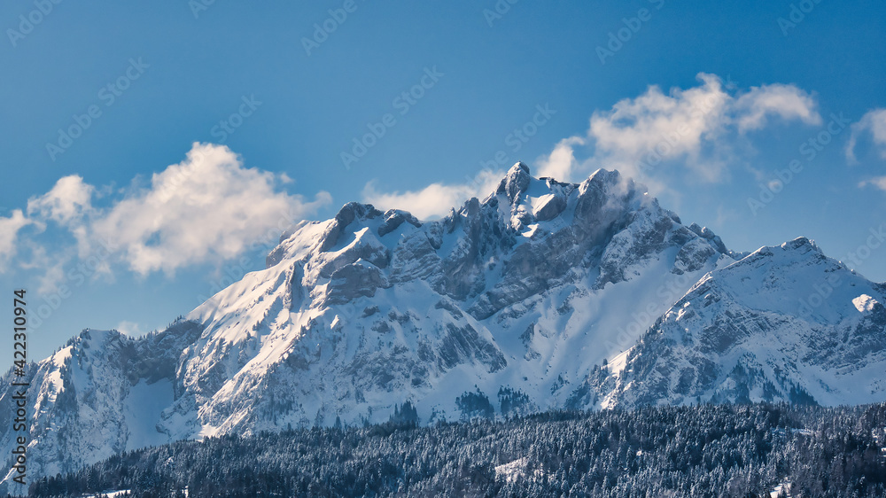 Snow covered Mount Pilatus against blue sky with few clouds