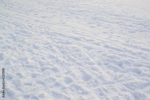 Trampled light white snow, footprints texture. Snowy winter park. Minimalism
