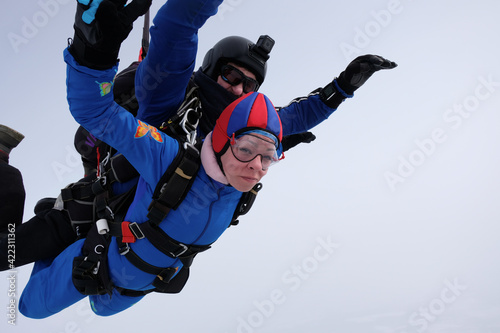 Skydiving. Tandem jump. Man and woman. Winter season.