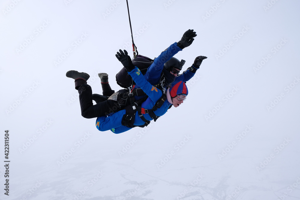 Skydiving. Tandem jump. Man and woman. Winter season. Skydiving. Tandem jump. Man and woman. Winter season.