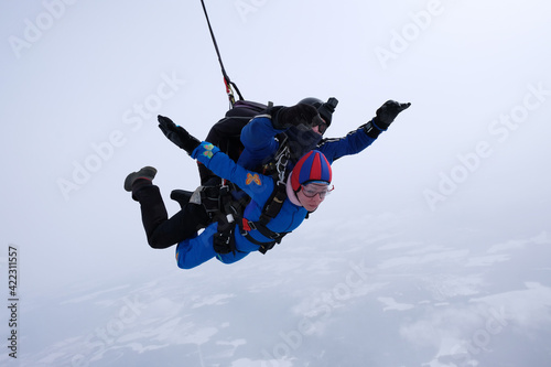 Skydiving. Tandem jump. Man and woman. Winter season.