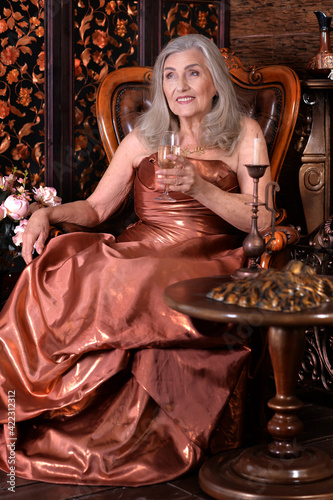 beautiful senior woman woman with champagne on chair © aletia2011