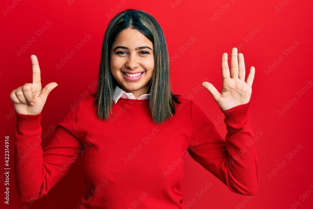 Young latin woman wearing casual clothes showing and pointing up with fingers number seven while smiling confident and happy.