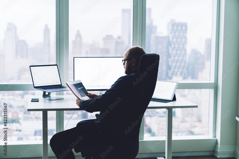 Focused man looking at trading graphs Focused man looking at trading graphs