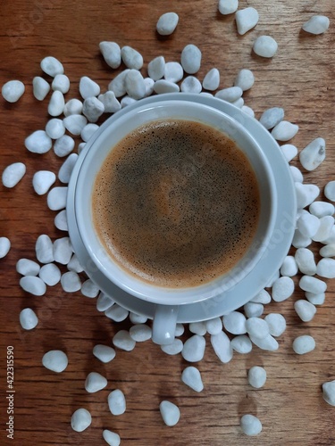 coffee cup on wooden table and stones background mobile photo