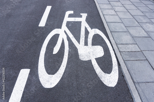 Bicycle lane background. Asphalt road for bikes. White paint bicycle painted on street. Pavement and bicycle lane. Walking and cycling path.