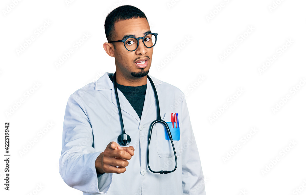 Young african american man wearing doctor uniform and stethoscope pointing displeased and frustrated to the camera, angry and furious with you Young african american man wearing doctor uniform and stethoscope pointing displeased and frustrated to the camera, angry and furious with you