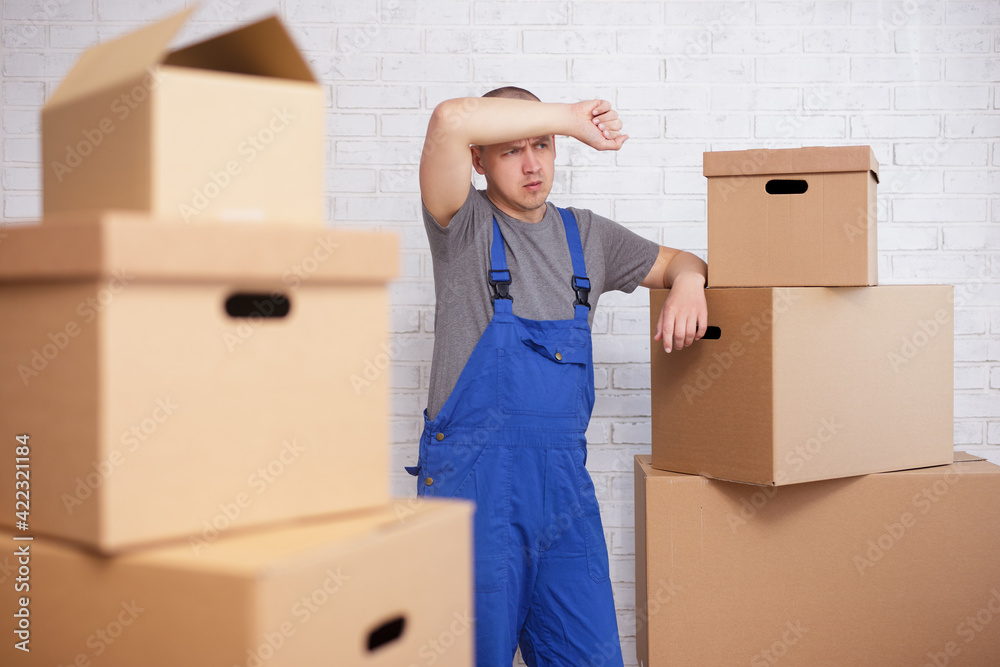 tired loader man between big cardboard boxes tired loader man between big cardboard boxes