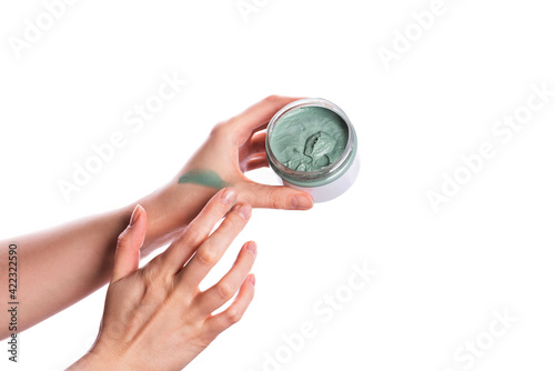 Jar of spirulina face clay mask in female hand photo