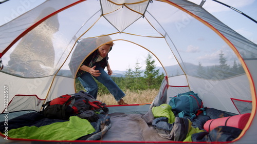 Hikers lying in tourist tent during hike in mountains.Happy man cuddling woman