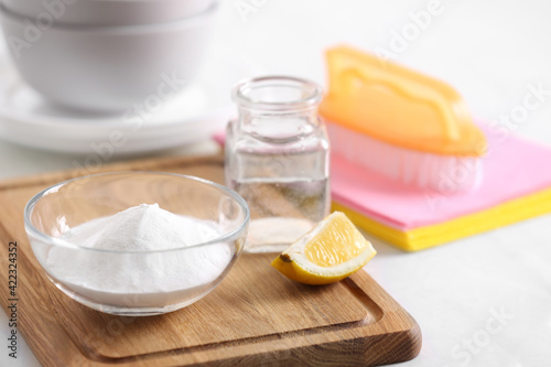 Baking soda, lemon and vinegar on white table. Eco friendly detergents