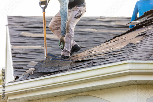 Photography roofer removing roof nails with roof shingle remover