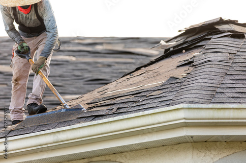 Photography roofer removing roof nails with roof shingle remover