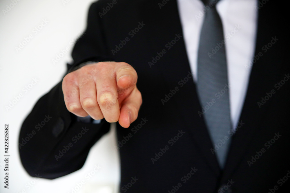 Businessman with black suite pointing his finger (focus on the finger)