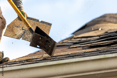 roofer removing roof nails with roof shingle remover