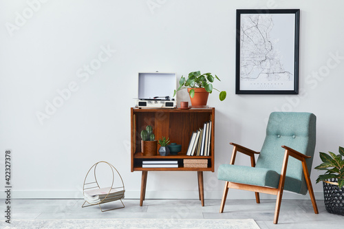 Retro composition of living room interior with mock up poster map, wooden shelf, book, stool, armchair, plant, cacti, vinyl recorder and personal accessories in stylish home decor.