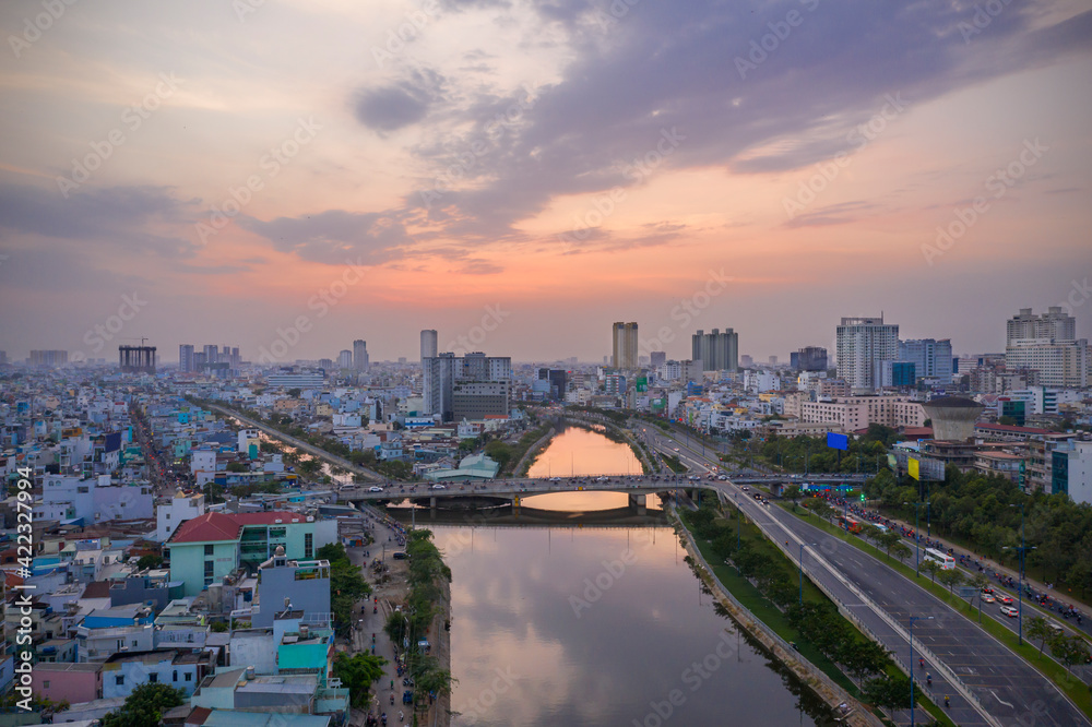 Sunset, bridge, canal, reflection and urban sprawl of Ho Chi Minh City District Eight 