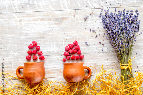 dry laveder bouquet, raspberry and straw on wooden background top view mockup photo