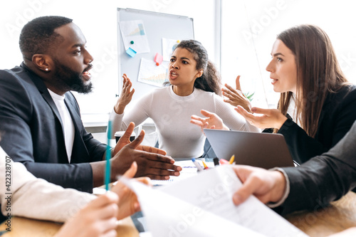 Angry business partners sitting in office on negotiations, cant coming to agreement. Multiethnic colleagues arguing, blame each other, failed a startup, unsuccess concept