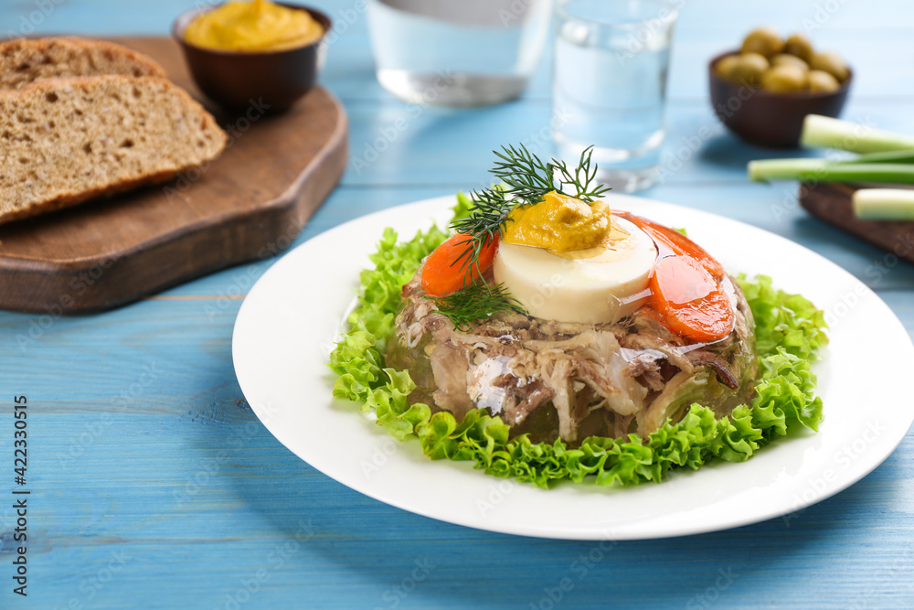Delicious aspic with meat and vegetables served on light blue wooden table