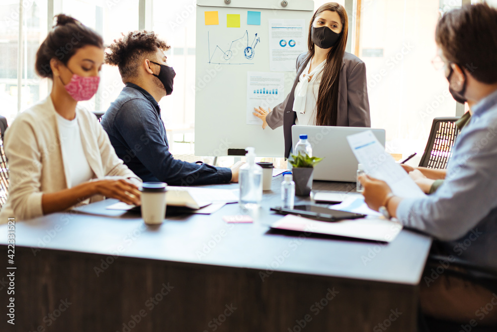 Business team wearing protective masks while meeting in the office during the COVID-19 epidemic Business team wearing protective masks while meeting in the office during the COVID-19 epidemic