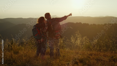 Man and woman having adventure in mountains. Hikers embracing together