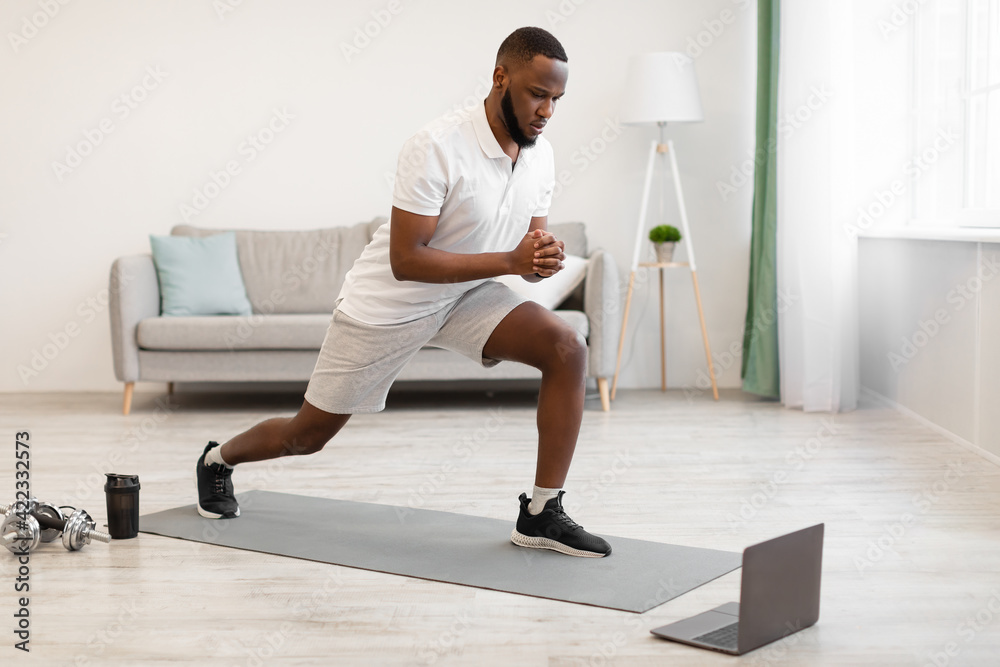 Black Guy Having Online Workout Doing Forward Lunge Exercise Indoors