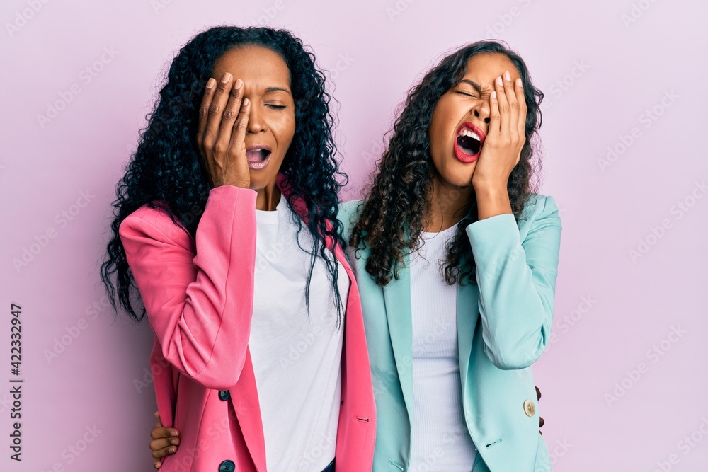 African american mother and daughter wearing business style yawning tired covering half face, eye and mouth with hand. face hurts in pain. African american mother and daughter wearing business style yawning tired covering half face, eye and mouth with hand. face hurts in pain.