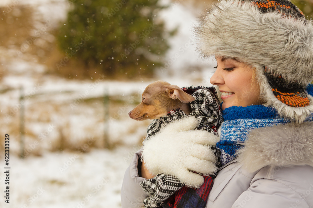 Woman hug warming her little dog in winter Woman hug warming her little dog in winter